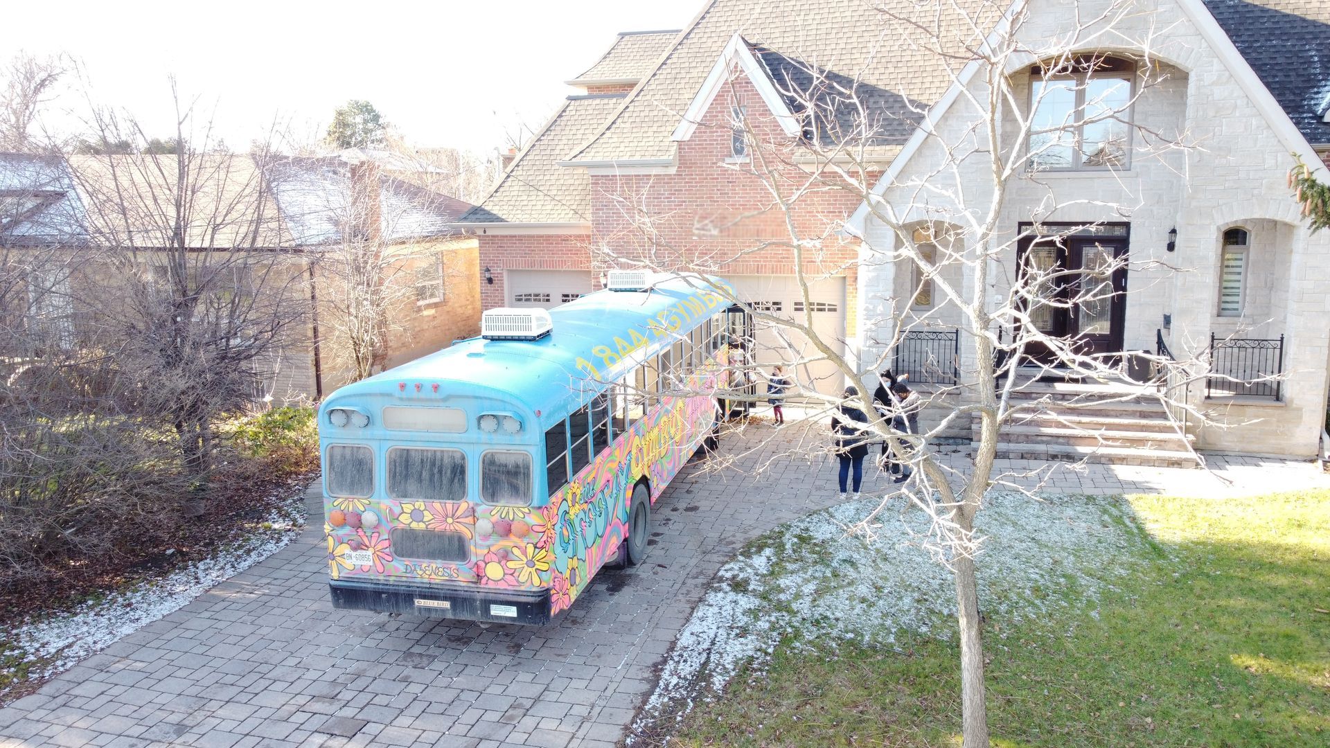 Bus parked on a driveway, balloons on the door